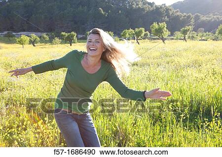Forty something year old woman in a meadow View Large Photo Image Stock Image - Forty something year old woman in a meadow. Fotosearch