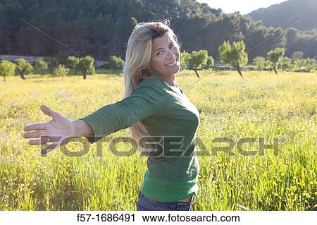 Forty something year old woman in a meadow View Large Photo Image Stock Image - Forty something year old woman in a meadow. Fotosearch