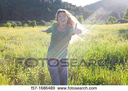 Forty something year old woman in a meadow View Large Photo Image Stock Photo - Forty something year old woman in a meadow. Fotosearch