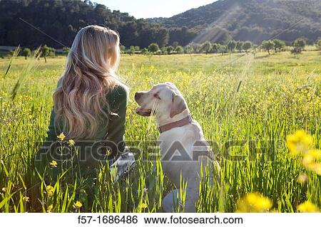 Forty something year old woman sitting in a meadow with her dog View Large Photo Image Stock Photograph - Forty something year old woman sitting in a meadow with her dog. Fotosearch