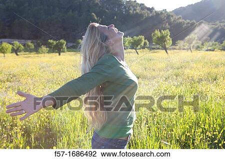 Forty something year old woman sun worshipping in a meadow View Large Photo Image Stock Image - Forty something year old woman sun worshipping in a meadow. Fotosearch