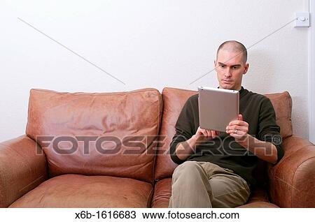 forty year old man using ipad tablet in casual setting View Large Photo Image Stock Image - forty year old man using ipad tablet in casual setting. Fotosearch