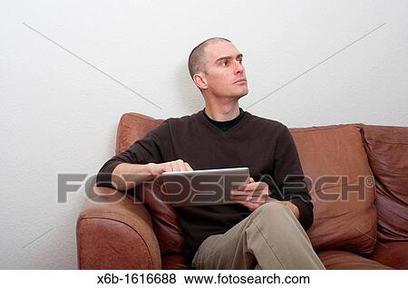 forty year old man using ipad tablet in casual setting View Large Photo Image Stock Photo - forty year old man using ipad tablet in casual setting. Fotosearch