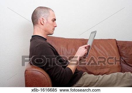 forty year old man using ipad tablet in casual setting View Large Photo Image Stock Photography - forty year old man using ipad tablet in casual setting. Fotosearch