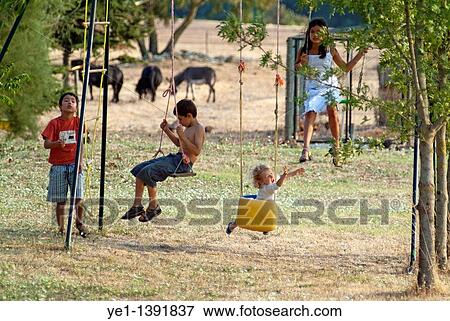 Four children playing on a swingset, Carcassonne, France View Large Photo Image Stock Photo - Four children playing on a swingset, Carcassonne, France. Fotosearch