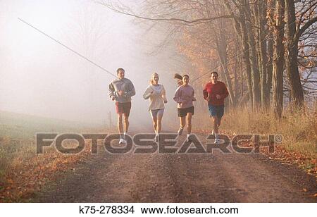 Picture - Four friends jogging on a country road. Fotosearch