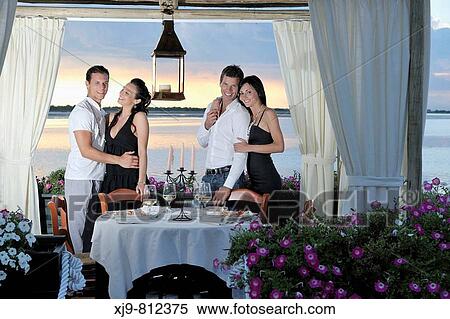 Stock Photography - Four friends who dine at the restaurant.. Fotosearch