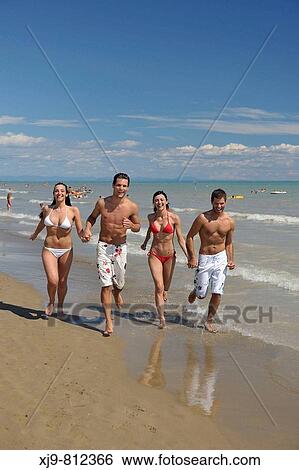 Four friends who run on the shore. View Large Photo Image Stock Photograph - Four friends who run on the shore.. Fotosearch