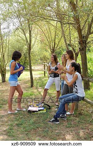 Stock Photo - four girls clapping to a friend. Fotosearch