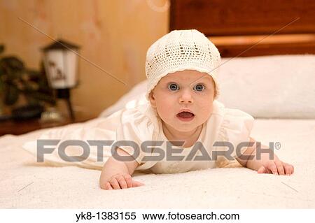 Stock Photography - Four month and two weeks old baby lying on bed. Fotosearch