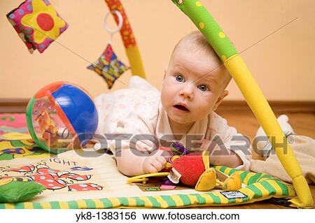 Four month old infant lying on playground with toys View Large Photo Image Stock Photograph - Four month old infant lying on playground with toys. Fotosearch
