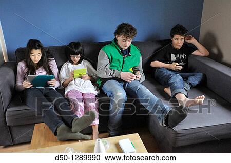 Four Swedish kids, two sisters and two brothers, ages 10 and 14, playing games on each otheir own tablets, digital tablet, smartphone, iPod and Nintendo, Krakow, Poland View Large Photo Image Stock Image - Four Swedish kids, two sisters and two brothers, ages 10 and 14, playing games on each otheir own tablets, digital tablet, smartphone, iPod and Nintendo, Krakow, Poland. Fotosearch