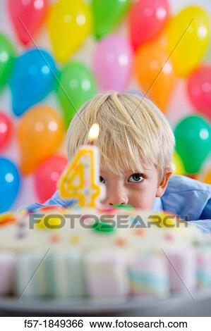 Stock Photograph - Four year old boy celebrating his birthday. Fotosearch