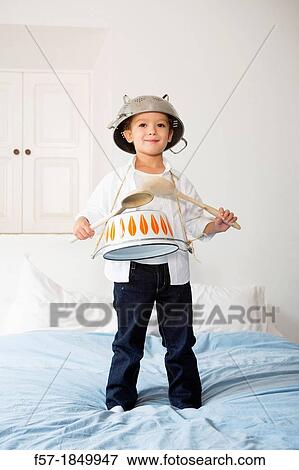 Stock Photo - Four year old boy drumming on a saucepan. Fotosearch