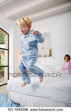 Stock Photo - Four year old boy jumping off the bed. Fotosearch