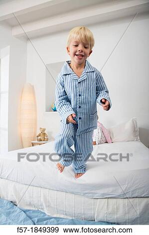 Stock Photo - Four year old boy jumping off the bed. Fotosearch