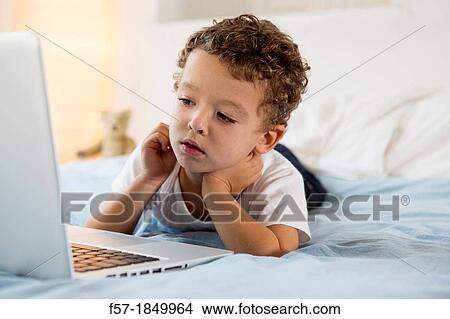 Four year old boy playing games on a laptop View Large Photo Image Picture - Four year old boy playing games on a laptop. Fotosearch
