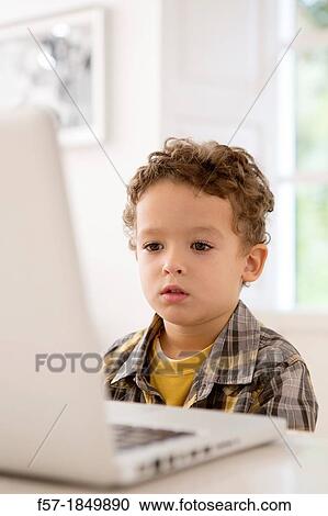 Four year old boy playing games on a laptop View Large Photo Image Stock Image - Four year old boy playing games on a laptop. Fotosearch