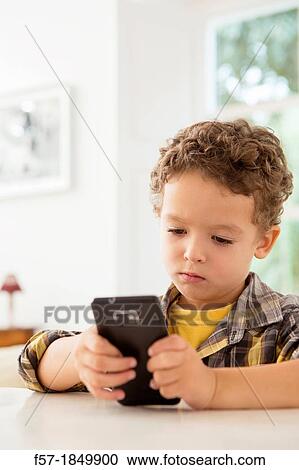 Four year old boy playing games on a cell phone View Large Photo Image Stock Image - Four year old boy playing games on a cell phone. Fotosearch