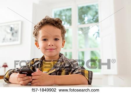 Four year old boy playing games on a cell phone View Large Photo Image Stock Image - Four year old boy playing games on a cell phone. Fotosearch