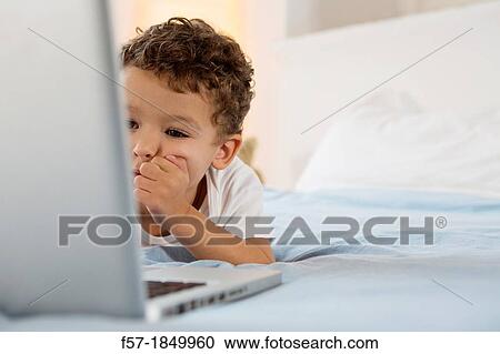 Four year old boy playing games on a laptop View Large Photo Image Stock Image - Four year old boy playing games on a laptop. Fotosearch