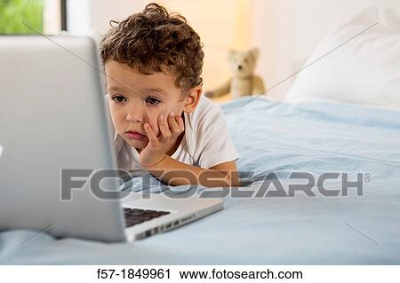 Four year old boy playing games on a laptop View Large Photo Image Stock Image - Four year old boy playing games on a laptop. Fotosearch