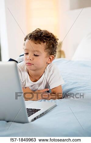 Four year old boy playing games on a laptop View Large Photo Image Stock Image - Four year old boy playing games on a laptop. Fotosearch