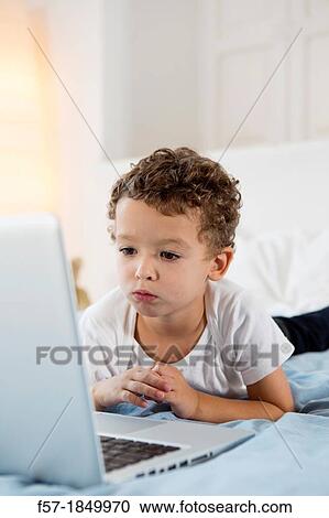 Four year old boy playing games on a laptop View Large Photo Image Stock Image - Four year old boy playing games on a laptop. Fotosearch