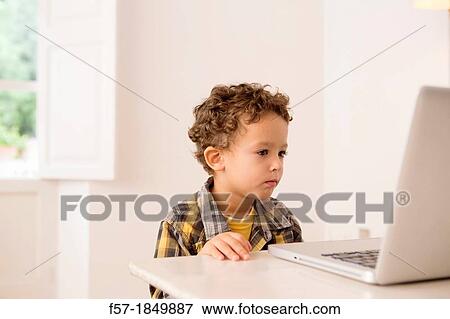 Four year old boy playing games on a laptop View Large Photo Image Stock Photo - Four year old boy playing games on a laptop. Fotosearch