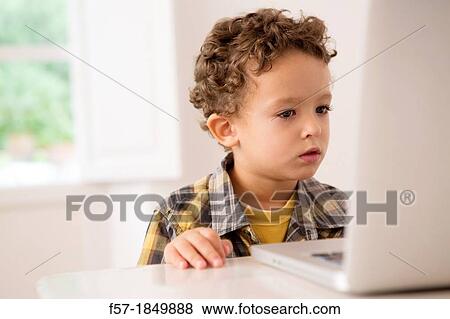 Four year old boy playing games on a laptop View Large Photo Image Stock Photo - Four year old boy playing games on a laptop. Fotosearch