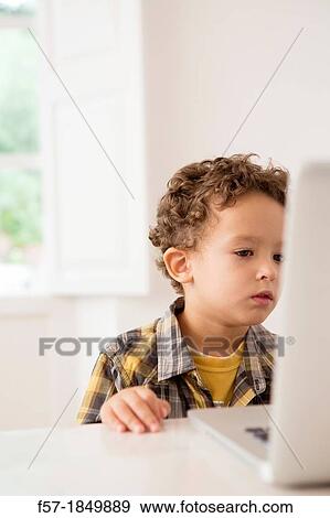 Four year old boy playing games on a laptop View Large Photo Image Stock Photo - Four year old boy playing games on a laptop. Fotosearch