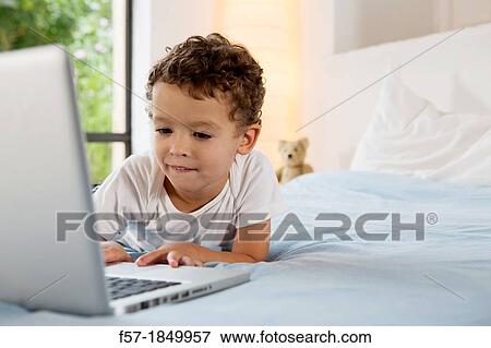 Four year old boy playing games on a laptop View Large Photo Image Stock Photo - Four year old boy playing games on a laptop. Fotosearch