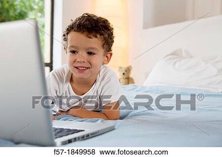 Four year old boy playing games on a laptop View Large Photo Image Stock Photo - Four year old boy playing games on a laptop. Fotosearch