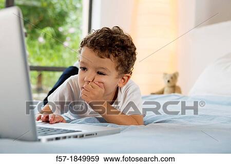 Four year old boy playing games on a laptop View Large Photo Image Stock Photo - Four year old boy playing games on a laptop. Fotosearch