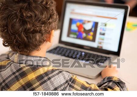 Four year old boy playing games on a laptop View Large Photo Image Stock Photograph - Four year old boy playing games on a laptop. Fotosearch