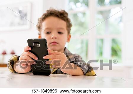 Four year old boy playing games on a cell phone View Large Photo Image Stock Photograph - Four year old boy playing games on a cell phone. Fotosearch