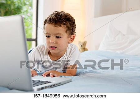Four year old boy playing games on a laptop View Large Photo Image Stock Photograph - Four year old boy playing games on a laptop. Fotosearch