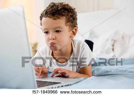Four year old boy playing games on a laptop View Large Photo Image Stock Photograph - Four year old boy playing games on a laptop. Fotosearch
