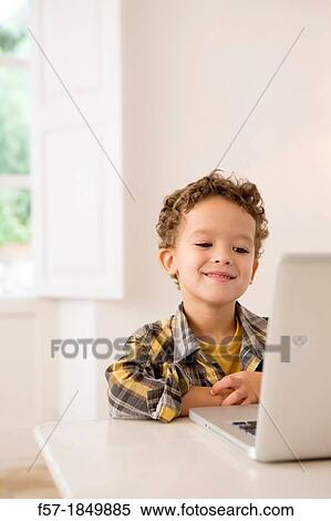 Stock Photography - Four year old boy playing games on a laptop. Fotosearch