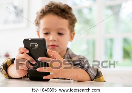 Four year old boy playing games on a cell phone View Large Photo Image Stock Photography - Four year old boy playing games on a cell phone. Fotosearch