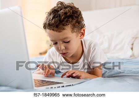 Four year old boy playing games on a laptop View Large Photo Image Stock Photography - Four year old boy playing games on a laptop. Fotosearch