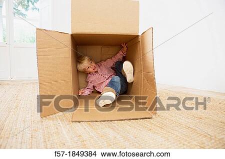 Four year old boy playing in a cardboard box View Large Photo Image Picture - Four year old boy playing in a cardboard box. Fotosearch
