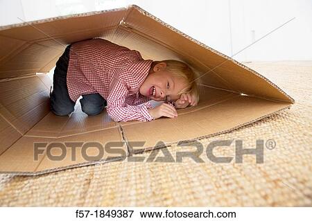 Four year old boy playing in a cardboard box View Large Photo Image Stock Photo - Four year old boy playing in a cardboard box. Fotosearch