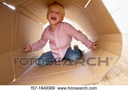 Four year old boy playing in a cardboard box View Large Photo Image Stock Photo - Four year old boy playing in a cardboard box. Fotosearch