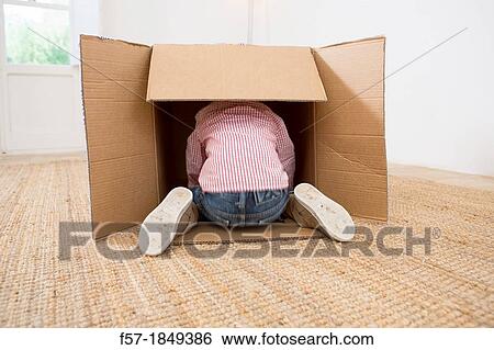 Stock Photograph - Four year old boy playing in a cardboard box. Fotosearch