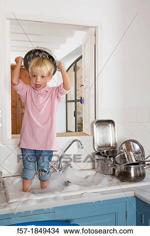Four year old boy playing in the kitchen sink View Large Photo Image Picture - Four year old boy playing in the kitchen sink. Fotosearch