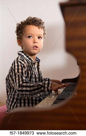 Four year old boy playing the piano View Large Photo Image Stock Image - Four year old boy playing the piano. Fotosearch