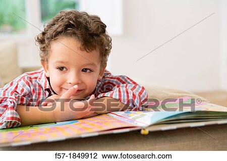 Four year old boy reading a book on the sofa View Large Photo Image Stock Image - Four year old boy reading a book on the sofa. Fotosearch