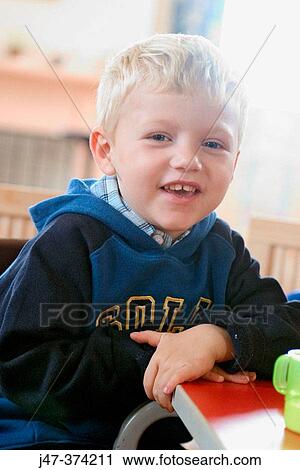 Four year old boy sitting at table at nursrey school, smiling to camera View Large Photo Image Stock Image - Four year old boy sitting at table at nursrey school, smiling to camera. Fotosearch