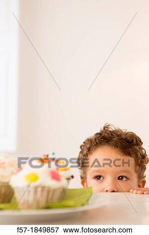 Stock Photo - Four year old boy waiting for a cupcake. Fotosearch